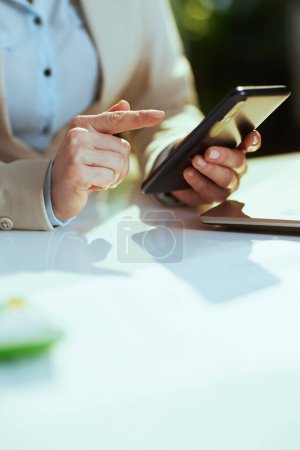 Photo for Closeup on business woman in green office with smartphone. - Royalty Free Image