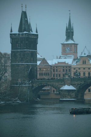 Foto de Paisaje en invierno en Praga, República Checa con el río Moldava, el puente de Carlos y el barco por la noche. - Imagen libre de derechos