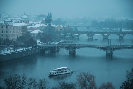 Foto de Paisaje en invierno en Praga, República Checa con el río Moldava, barco y puente. - Imagen libre de derechos