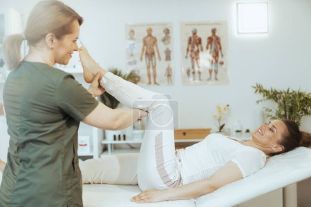 Téléchargez les photos : Temps de santé. heureuse massothérapeute femme dans l'armoire de massage avec client conduisant l'examen. - en image libre de droit