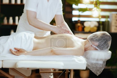 Foto de Tiempo de atención médica. masajista en salón de spa cliente de masaje en mesa de masaje. - Imagen libre de derechos