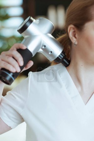 Photo for Healthcare time. Closeup on massage therapist woman in spa salon with massage pistol. - Royalty Free Image