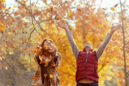 Foto de Hola otoño. feliz familia con estilo en el parque lanzando hojas de otoño. - Imagen libre de derechos
