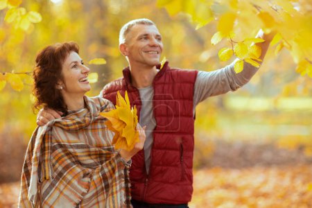 Foto de Hola otoño. sonriente romántico novio y novia en el parque con hojas de otoño caminando. - Imagen libre de derechos