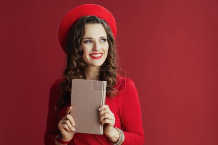 Photo for Happy Valentine. smiling elegant middle aged woman in red dress and beret on red background with book. - Royalty Free Image
