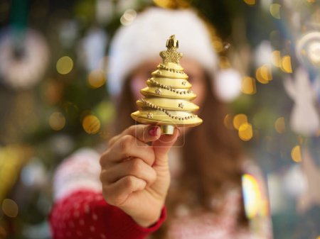 Photo for Christmas time. Closeup on woman with Santa hat showing Christmas toy near Christmas tree at home. - Royalty Free Image