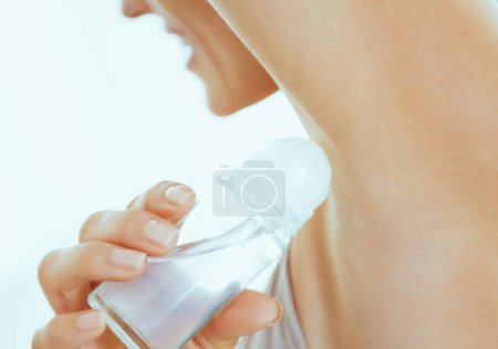 Photo for Closeup on young woman applying deodorant on underarm - Royalty Free Image