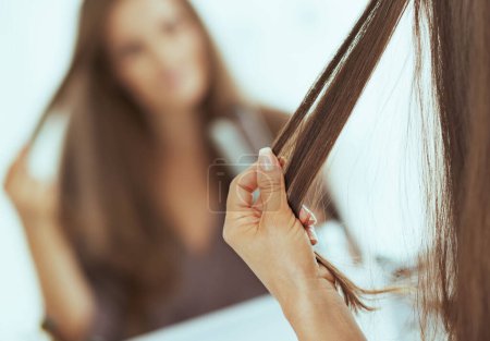 Foto de Primer plano de la mujer que comprueba el cabello después de alisar - Imagen libre de derechos