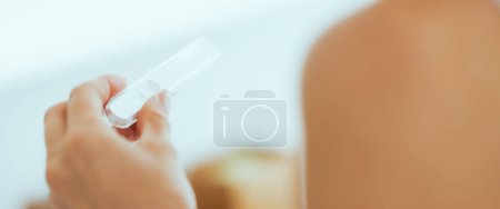 Foto de Primer plano de la mujer joven que busca en la prueba de embarazo - Imagen libre de derechos