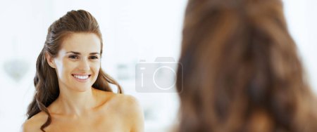 Foto de Sonriente joven mujer mirando en el espejo - Imagen libre de derechos
