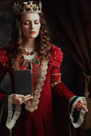 Photo for Medieval queen in red dress with book and crown. - Royalty Free Image