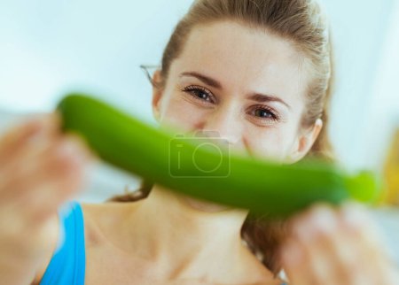 Photo for Young woman smiling with zucchini - Royalty Free Image