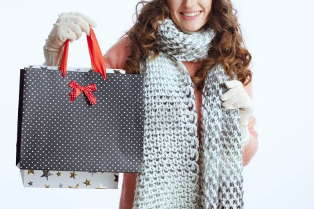 Photo for Hello winter. Closeup on trendy 40 years old woman in sweater, mittens, hat and scarf against white background with shopping bags. - Royalty Free Image