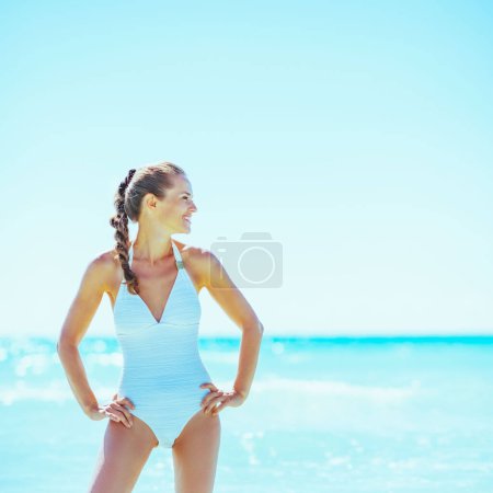 Photo for Happy young woman standing in sea and looking on copy space - Royalty Free Image