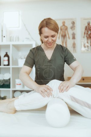 Foto de Tiempo de atención médica. sonriente masaje terapeuta mujer en masaje gabinete con cliente realización de examen. - Imagen libre de derechos