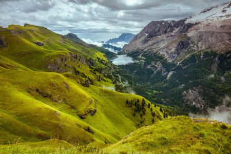Téléchargez les photos : Heure d'été dans les Dolomites. paysage avec montagnes, collines, lac Fedaia, nuages et forêt. - en image libre de droit
