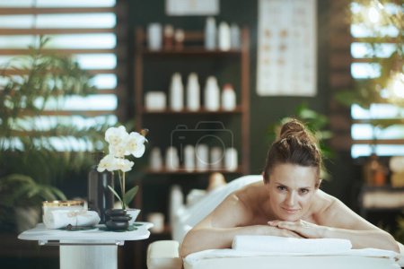 Téléchargez les photos : Temps de santé. moderne détendue femme d'âge moyen dans l'armoire de massage pose sur la table de massage. - en image libre de droit