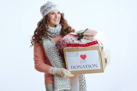 Photo for Hello winter. happy stylish woman in sweater, mittens, hat and scarf isolated on white background with donation box. - Royalty Free Image