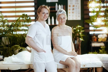 Foto de Tiempo de atención médica. terapeuta de masaje médico en gabinete de masaje con cliente relajado en mesa de masaje. - Imagen libre de derechos