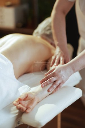 Téléchargez les photos : Temps de santé. Gros plan sur massothérapeute dans le salon de spa massant les clients bras sur table de massage. - en image libre de droit
