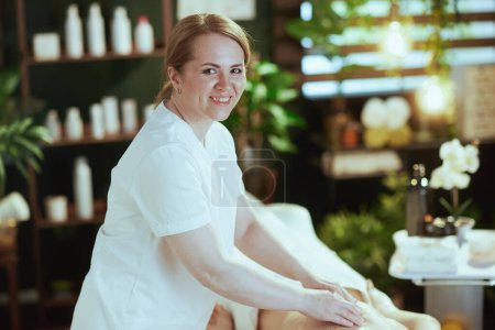 Photo for Healthcare time. smiling medical massage therapist in massage cabinet massaging client. - Royalty Free Image