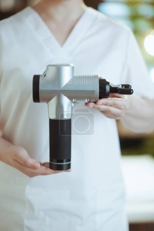Photo for Healthcare time. Closeup on female medical massage therapist in massage cabinet with massage pistol. - Royalty Free Image