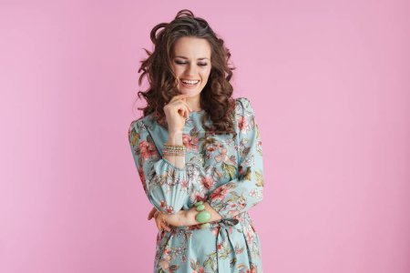 Photo for Smiling trendy female in floral dress with bracelets isolated on pink background. - Royalty Free Image