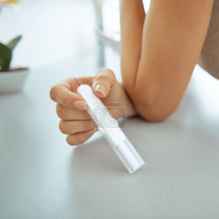 Foto de Primer plano de la mujer joven que muestra la prueba de embarazo en el baño - Imagen libre de derechos