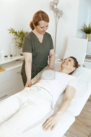 Téléchargez les photos : Temps de santé. heureuse massothérapeute femme dans l'armoire de massage avec client faisant check-up. - en image libre de droit