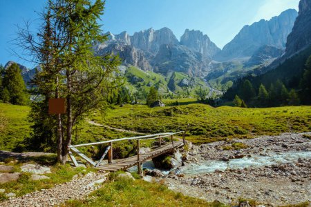 Foto de Hora de verano en Dolomitas. paisaje con montañas, río, árboles y puente. - Imagen libre de derechos