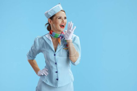 Photo for Happy stylish stewardess woman on blue background in blue uniform shouting. - Royalty Free Image