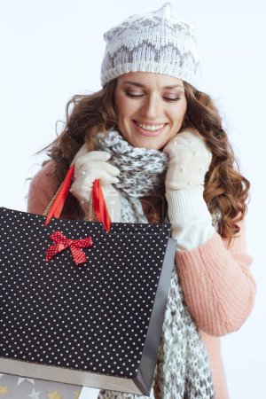 Foto de Hola invierno. mujer moderna feliz en suéter, manoplas, sombrero y bufanda aislados sobre fondo blanco con bolsas de compras. - Imagen libre de derechos