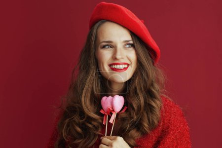 Photo for Happy Valentine. happy modern woman in red sweater and beret with hearts on stick. - Royalty Free Image