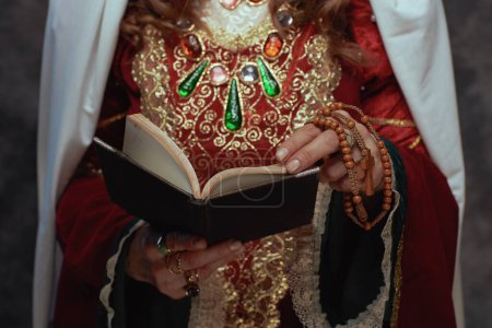 Téléchargez les photos : Gros plan sur la reine médiévale en robe rouge avec livre. - en image libre de droit