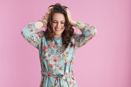 Photo for Cheerful elegant 40 years old woman in floral dress against pink background. - Royalty Free Image