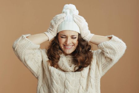 Téléchargez les photos : Hello winter. happy stylish female in beige sweater, mittens and hat isolated on beige background. - en image libre de droit