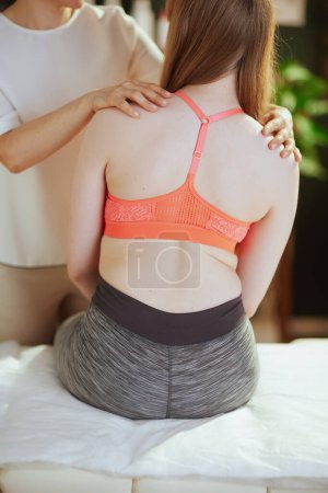 Photo for Healthcare time. Closeup on massage therapist woman in massage cabinet with teenage client checking clients back condition during examination. - Royalty Free Image