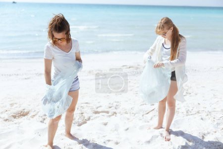Photo for Concerned eco activists on the seashore with trash bags collecting waste. - Royalty Free Image