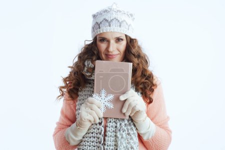 Téléchargez les photos : Bonjour l'hiver. femme moderne en pull, mitaines, chapeau et écharpe isolé sur fond blanc avec flocon de neige et livre. - en image libre de droit