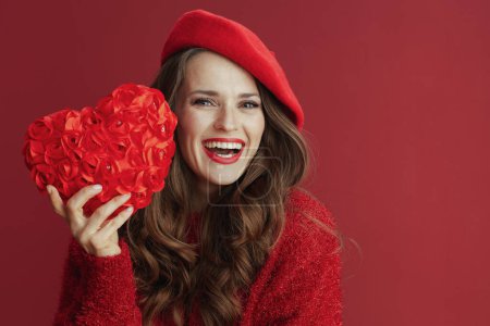 Photo for Happy Valentine. smiling elegant 40 years old woman in red sweater and beret with red heart and long wavy hair. - Royalty Free Image