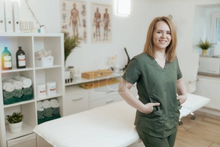 Téléchargez les photos : Temps de santé. heureuse femme thérapeute de massage médical dans l'armoire de massage regardant la caméra. - en image libre de droit