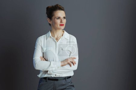 Téléchargez les photos : Coûteux propriétaire de petite entreprise à la mode femme en chemisier blanc regardant l'espace de copie isolé sur gris. - en image libre de droit
