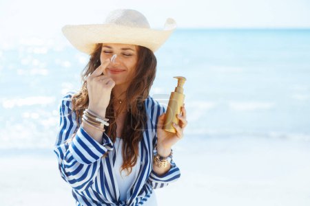 Photo for Smiling modern female on the beach with spf. - Royalty Free Image