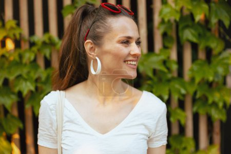 Téléchargez les photos : L'heure d'été. jeune femme souriante en chemise blanche près du mur en bois. - en image libre de droit