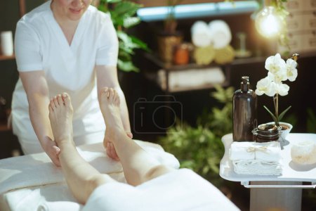 Foto de Tiempo de atención médica. Primer plano del terapeuta de masaje médico en el gabinete de masaje que masajea a los clientes pierna sobre mesa de masaje. - Imagen libre de derechos