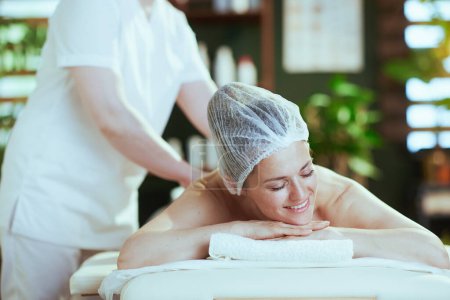 Photo for Healthcare time. medical massage therapist in spa salon with relaxed client do a therapeutic massage on massage table. - Royalty Free Image