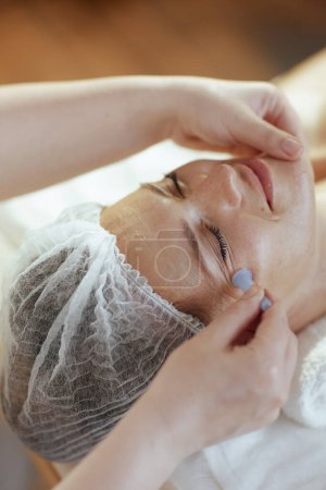 Foto de Tiempo de atención médica. masaje terapeuta en gabinete de masaje con silicona masaje taza masaje clientes cara. - Imagen libre de derechos