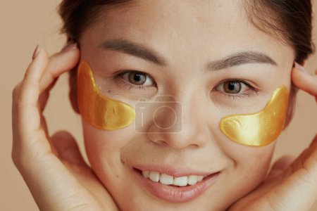 Photo for Portrait of young woman with eye patches on beige background. - Royalty Free Image