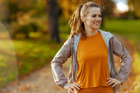 Photo for Hello autumn. happy stylish woman in fitness clothes in the park relaxing after workout. - Royalty Free Image