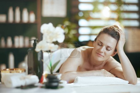 Photo for Healthcare time. relaxed modern 40 years old woman in spa salon laying on massage table. - Royalty Free Image